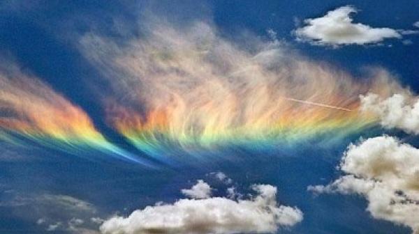 A rainbow in the sky with clouds
