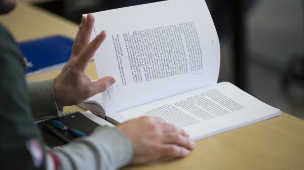 A student holds open a book during class