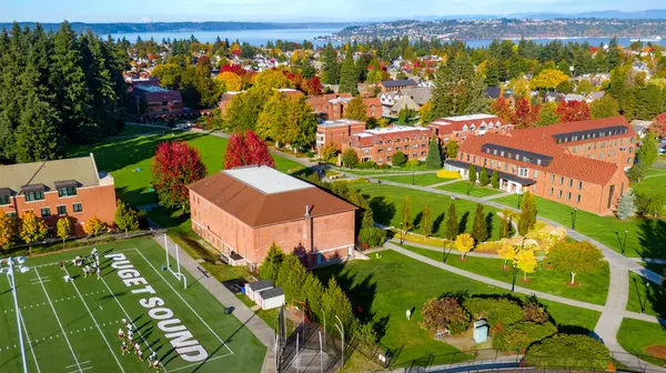 Aerial image of campus with red brick buildings and fall foliage.