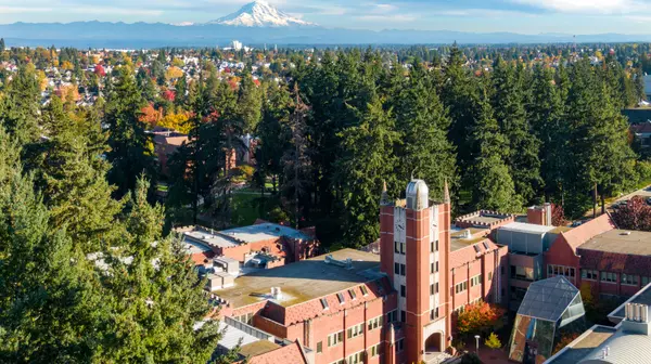 image of red brick buildings and courtyard in the foreground and Mount Rainier in the distance