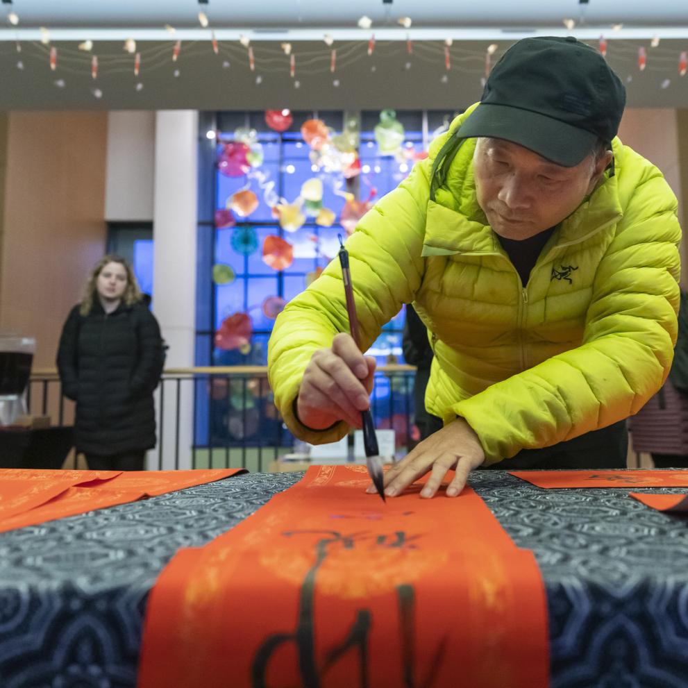 Prof. Zaixin Hong does calligraphy during a Lunar New Year celebration.