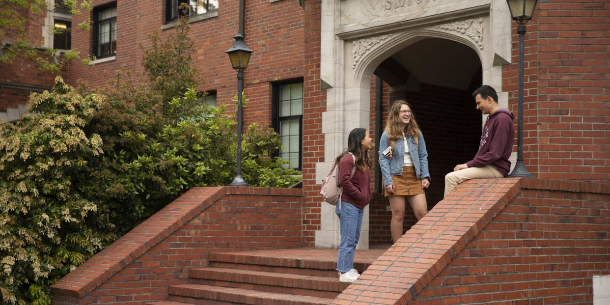 Students chatting on the steps to a residence hall