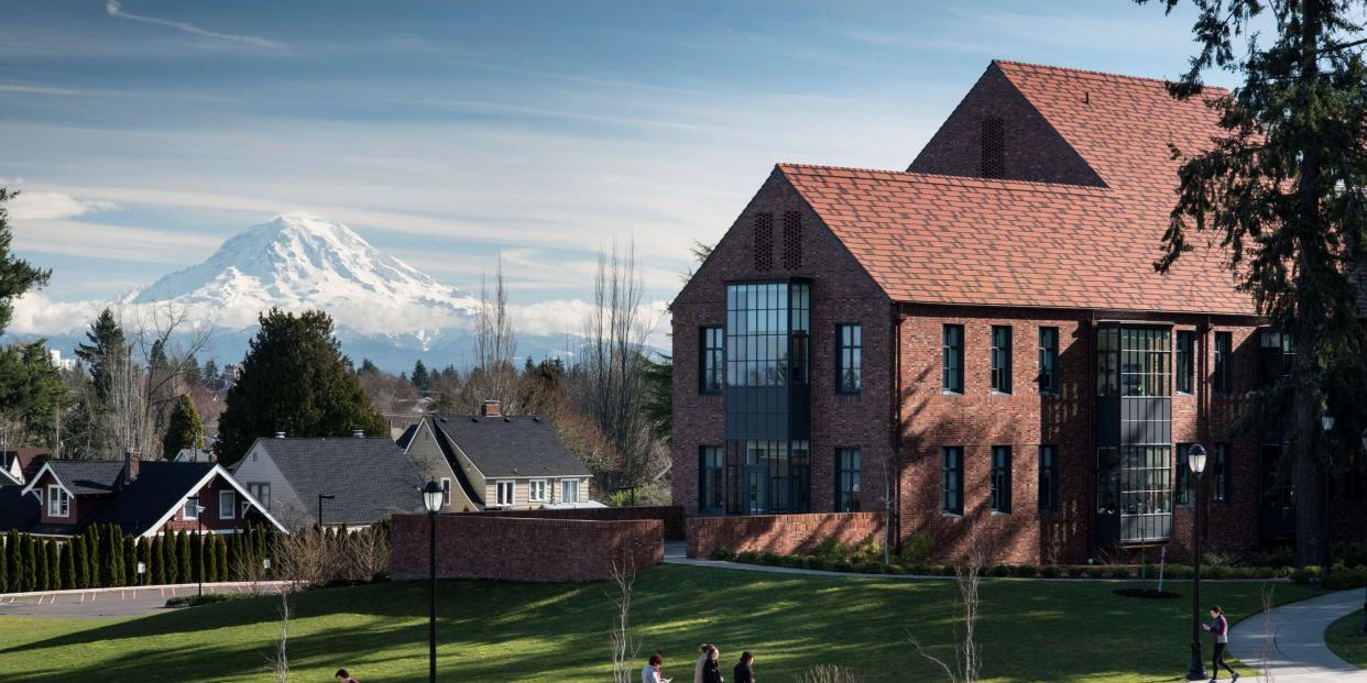Students walking near Weyerhaeuser Hall and the Event Lawn with Mount Rainier in the background