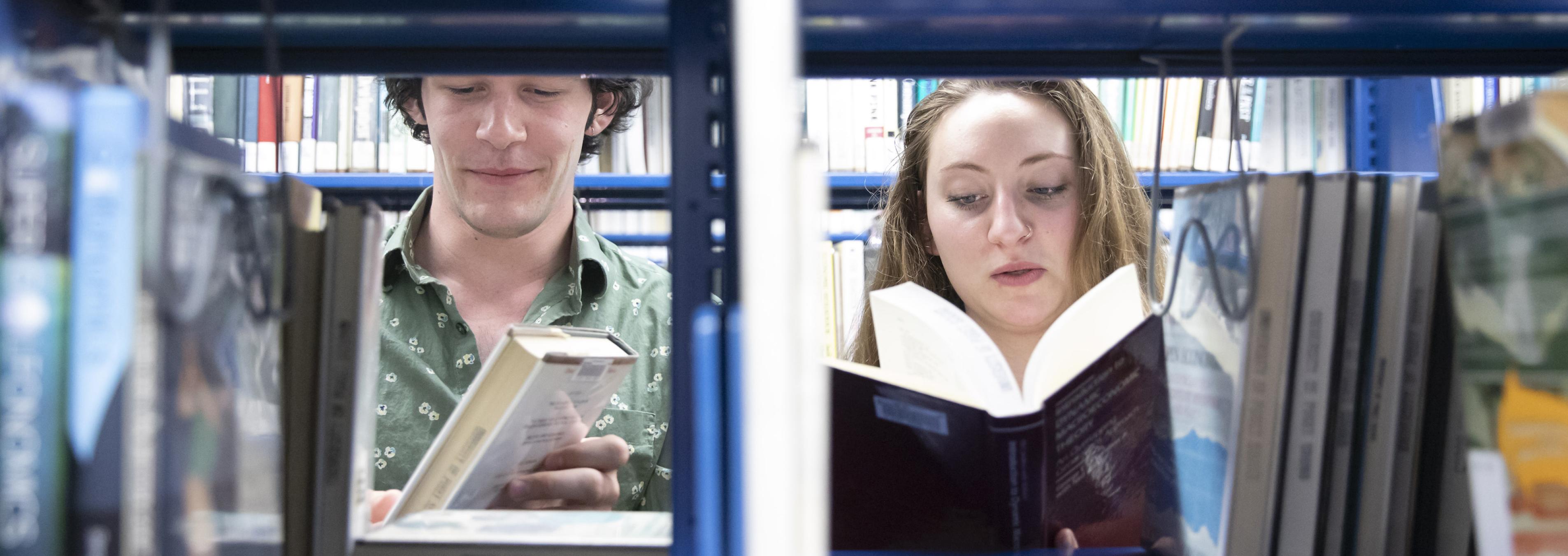Two students peruse books in Collins Memorial Library.