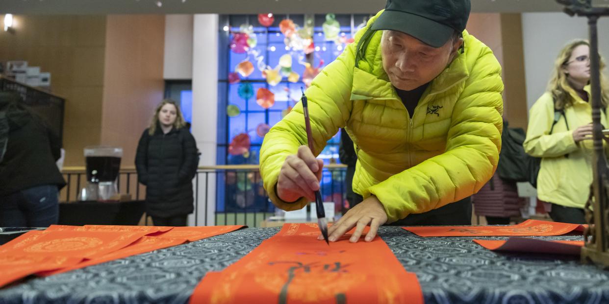 Prof. Zaixin Hong does calligraphy during the Lunar New Year celebration.