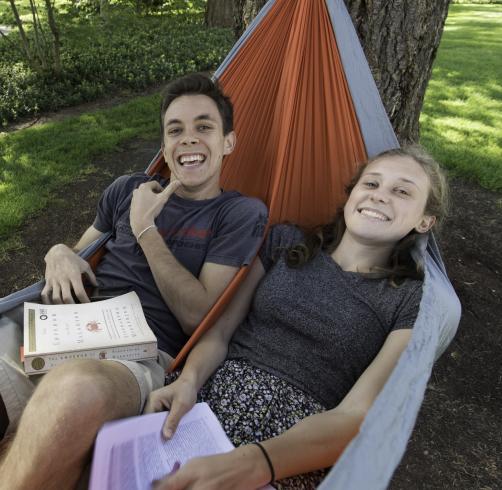 Students studying in a hammock on campus in the spring