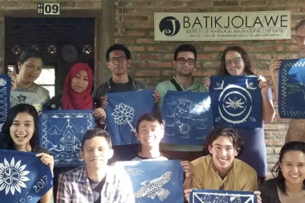 A group of people holding up Batik artwork