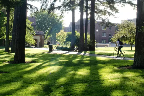 A person riding a bike across campus
