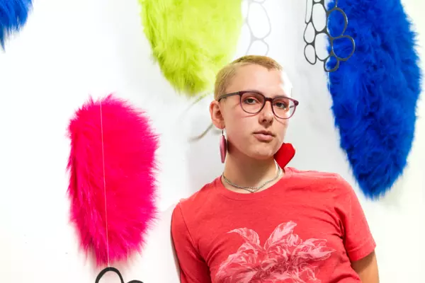 A person posing in front of an art exhibit