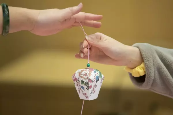 Hands holding an Asian decoration