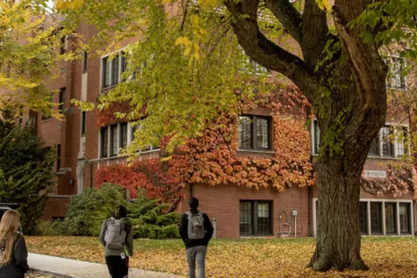 People walking through campus during Fall season colors
