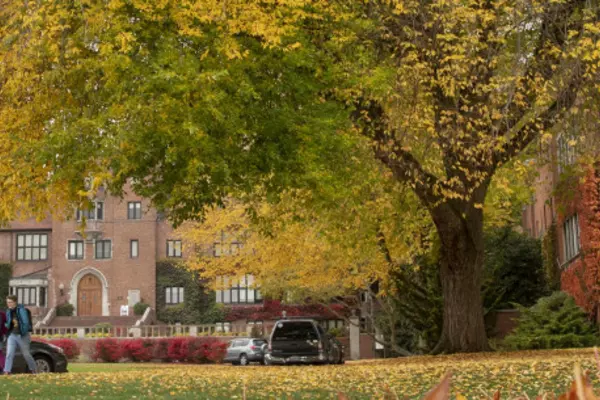 People walking across campus during Fall season colors