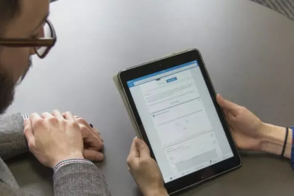Two people at a table looking at a tablet screen