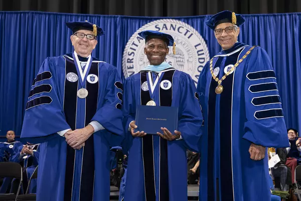 President Isiaah Crawford receives honorary degree, flanked by Joseph P. Conran (left) and Fred P. Pestello (right)