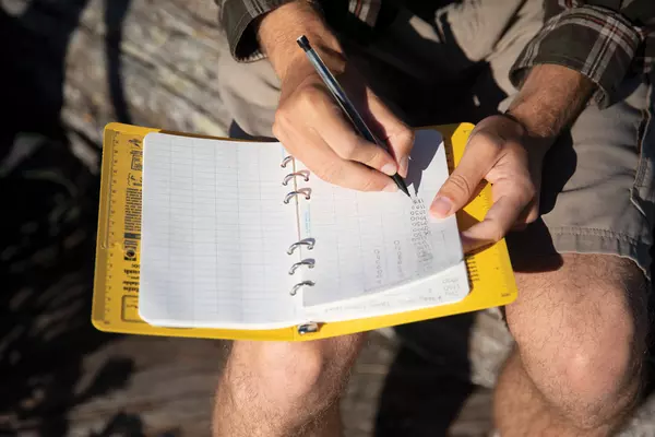 A student makes notes in a logbook