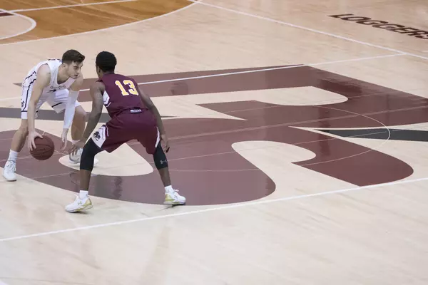 Basketball players on the PS on the key on the court in Warner Gym