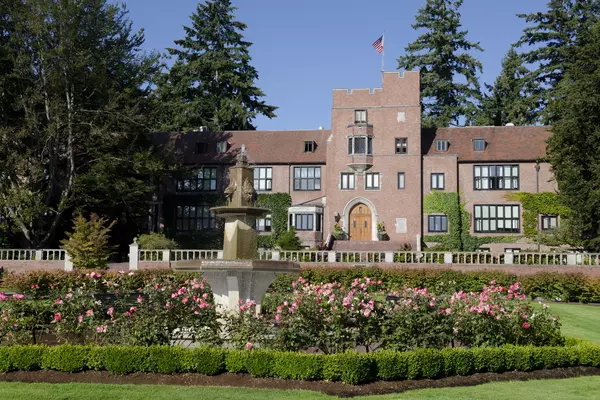 Jones Hall sits in behind a garden of flowers on campus. 