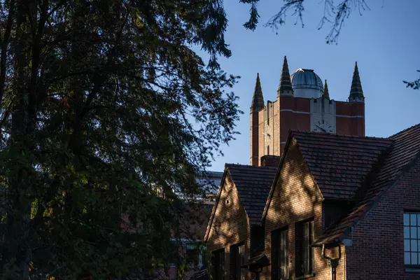Collegiate gothic building seen with trees in the foreground. 