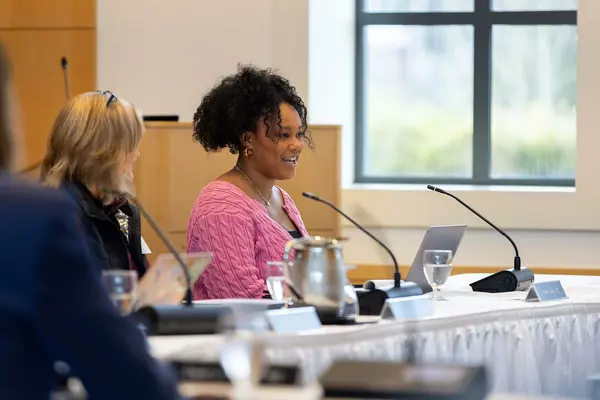 Kevoni Neely smiles while in a board of trustees meeting. 