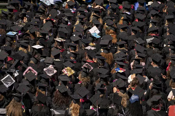 Students seated in rows for Commencement with their caps and gowns