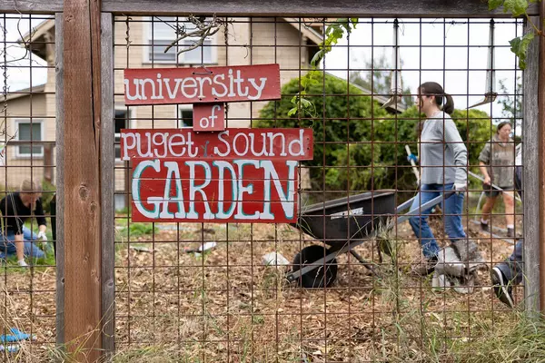 University of Puget Sound Garden sign on a gate surrounding a garden. 