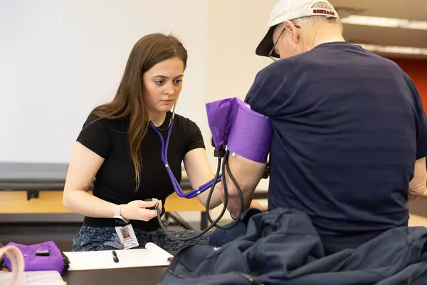 Woman checks a patients blood pressure
