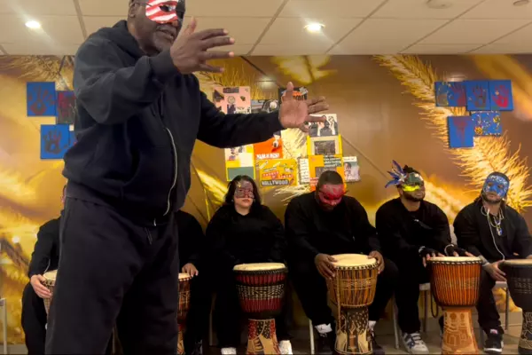 Alex Anderson stands in front of a group