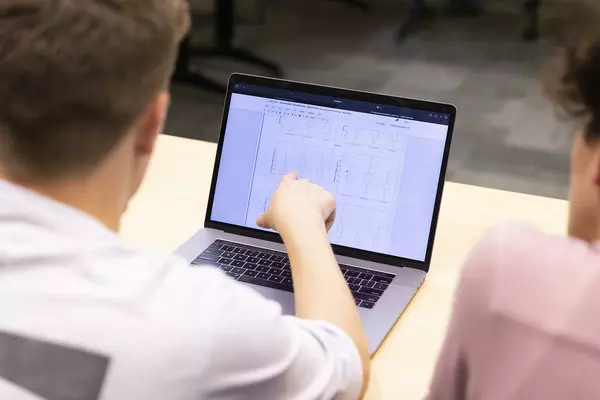 Student points at the laptop screen