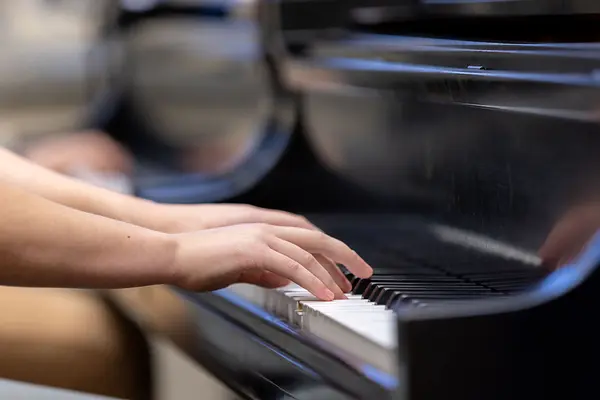 Hands on a piano keyboard