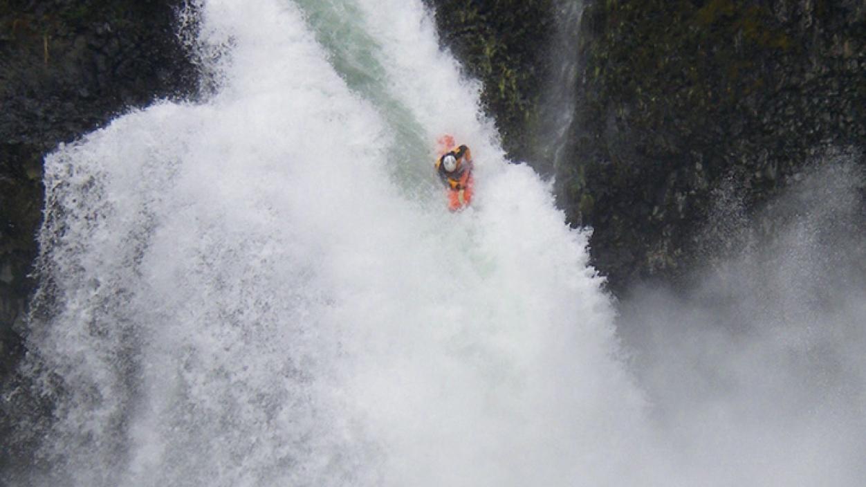Jonathan Blum ’06 rides a waterfall in his orange kayak.
