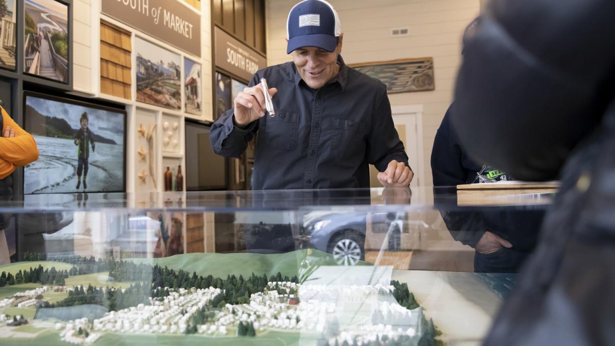 Casey Roloff points to a scale model of the town