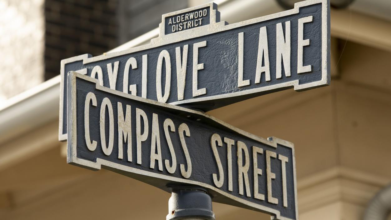 Street name signs at the intersection of Foxglove Lane and Compass Street