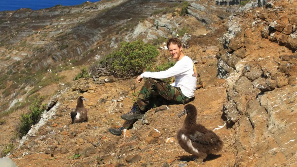 A person sitting on a rocky hill