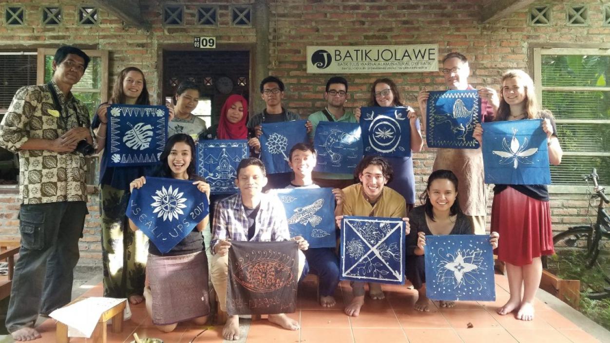 A group of people holding up Batik artwork