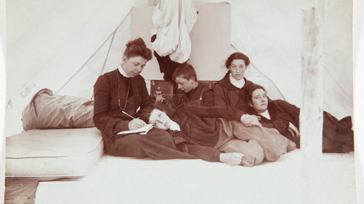 A black and white family portrait inside a tent