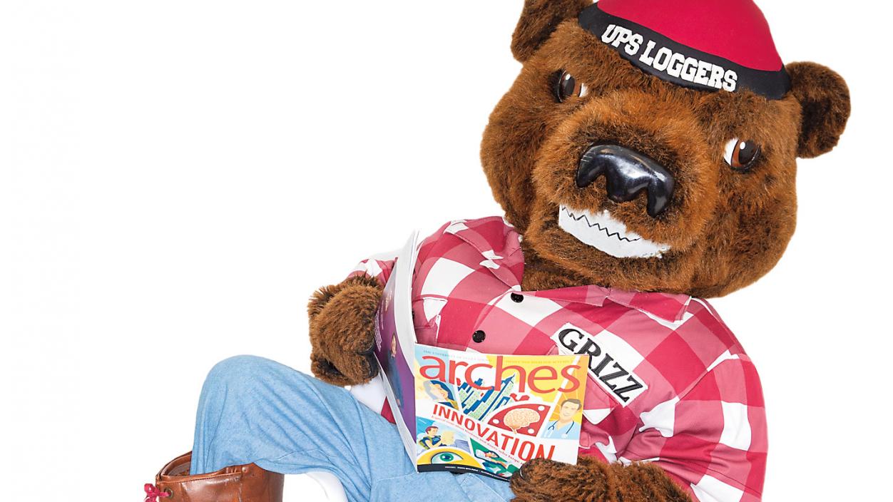 Grizz in a chair, reading Arches magazine