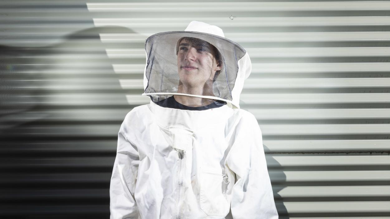 Adam Schmidt ’23 in a white beekeeper suit