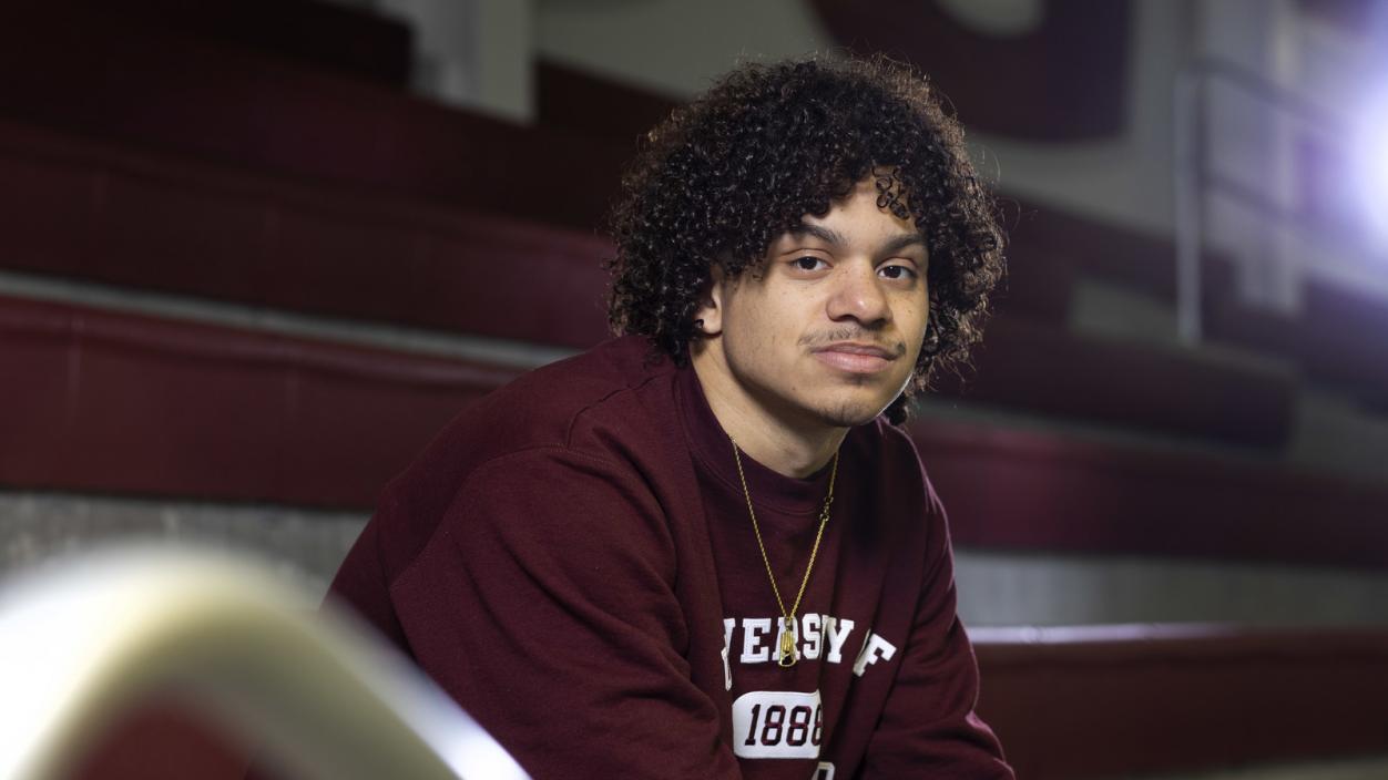 Jaden Francis ’25 sits in the stands beside Wallace Pool in the Athletics and Aquatics Center