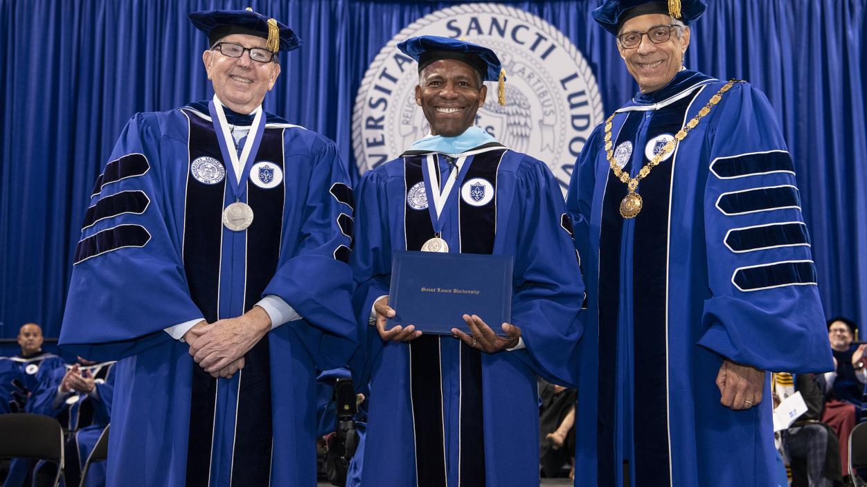 President Isiaah Crawford receives an honorary degree, flanked by Joseph P. Conran (left) and Fred P. Pestello (right)