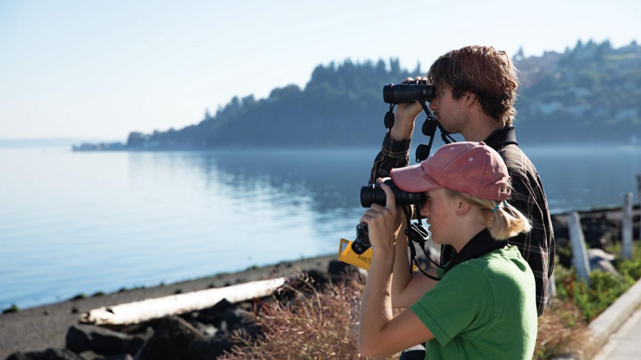 Students peer through binoculars at the Puget Sound