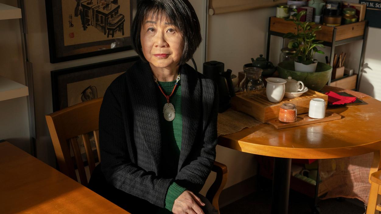 Lotus Perry sits in her office with a tea set on a table behind her.
