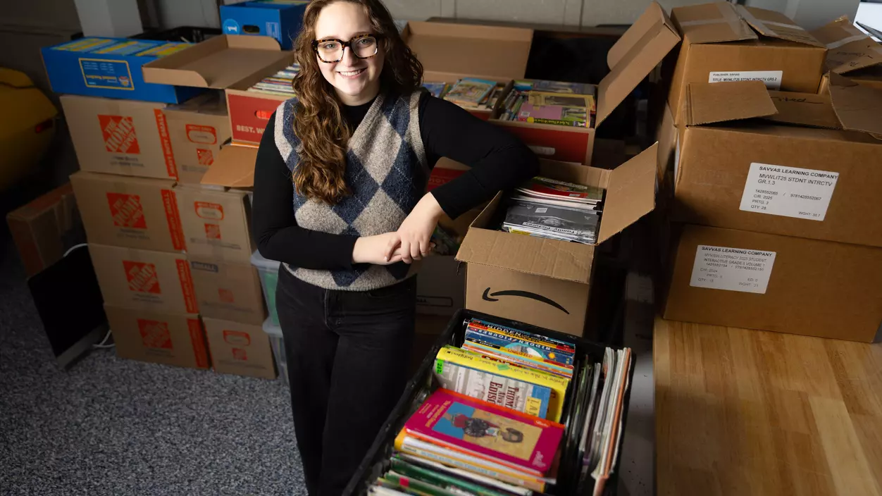Hurley Scholar Abi Longbottom ’26 with books she collected to donate to schools in Kenya.