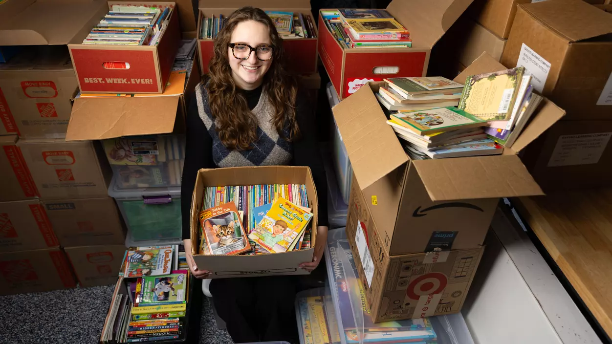 Hurley Scholar Abi Longbottom ’26 with books she collected to donate to schools in Kenya.