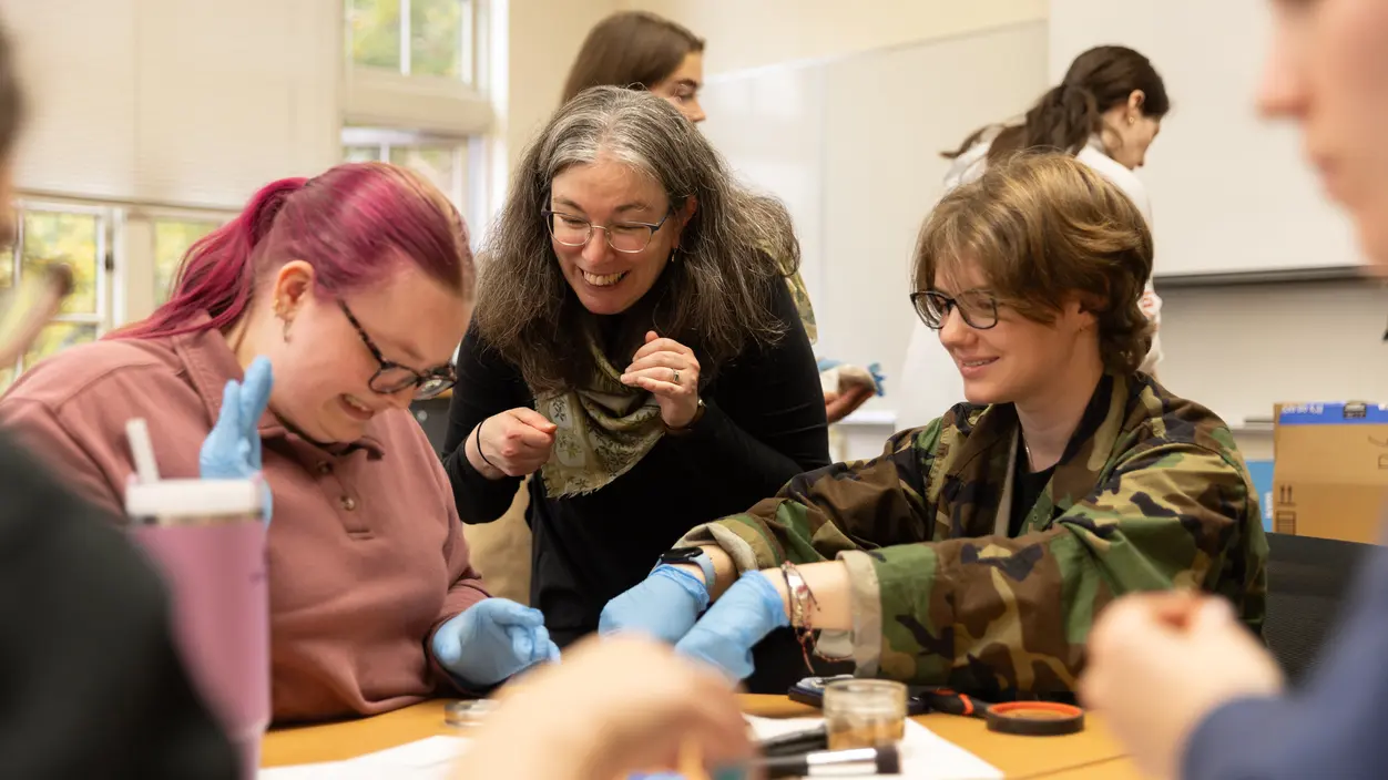 Prof. Amy Fisher works with students in class.