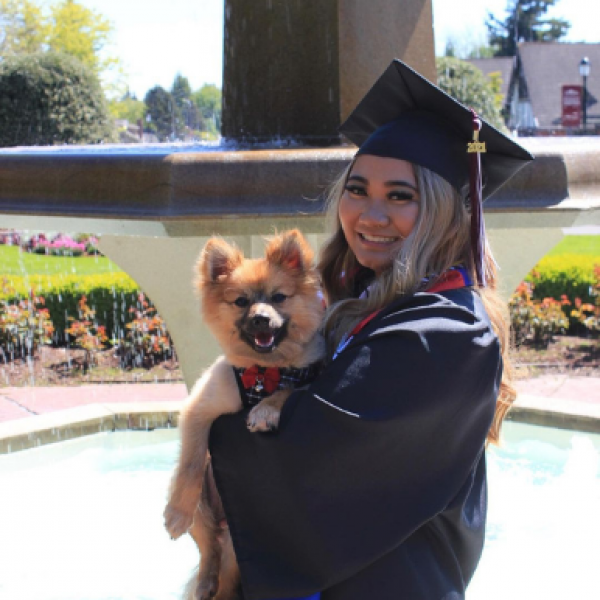 Puget Sound grad holding small dog on campus