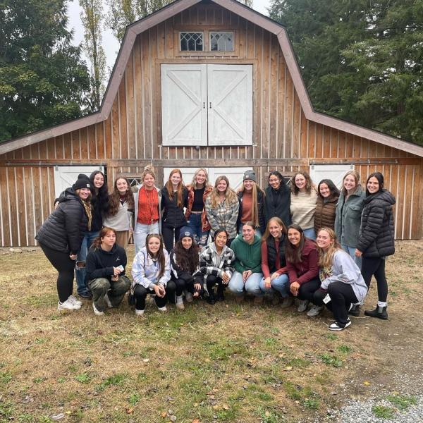 Puget Sound softball team in front of a barn