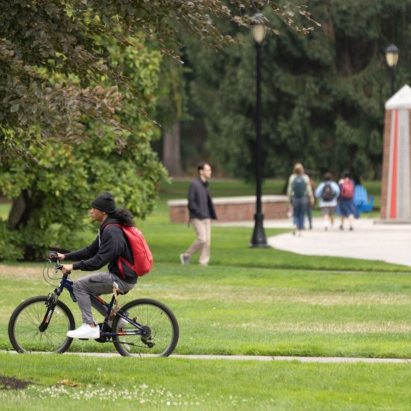 Students walking and riding bikes on campus near Karlen Quad and the Color Post.