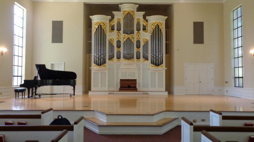 A piano and a pipe organ on a stage