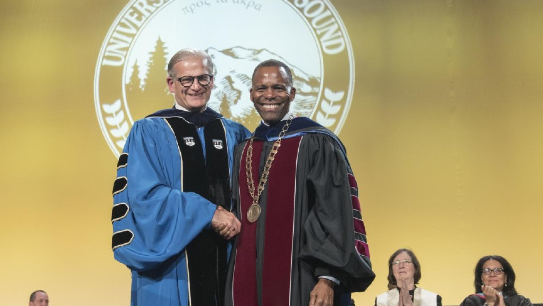 President Emeritus Ron Thomas presenting President Isiaah Crawford with the university medallion during the Installation Ceremony. Photo by Ross Mulhausen.