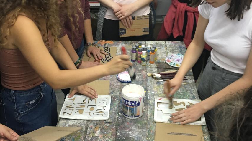 A group of people painting with stencils
